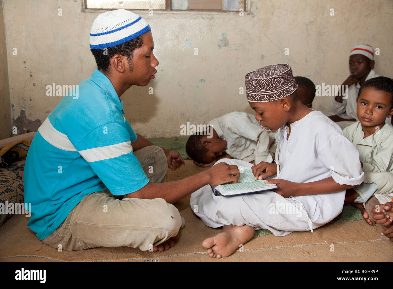 Zanzibar, Tanzania. Imam Helping Young Boy in a Madrassa (Koranic School) Read Verses in the Koran. Stock Photo
