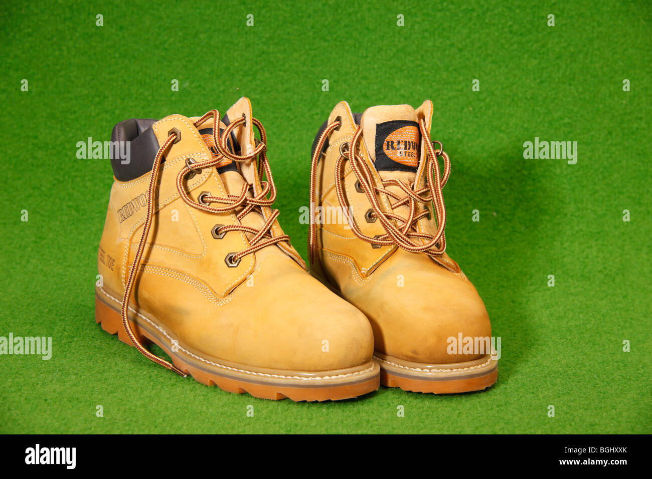 A pair of tan coloured Redwood steel toe capped workman s safety boots on green background Stock Photo Alamy