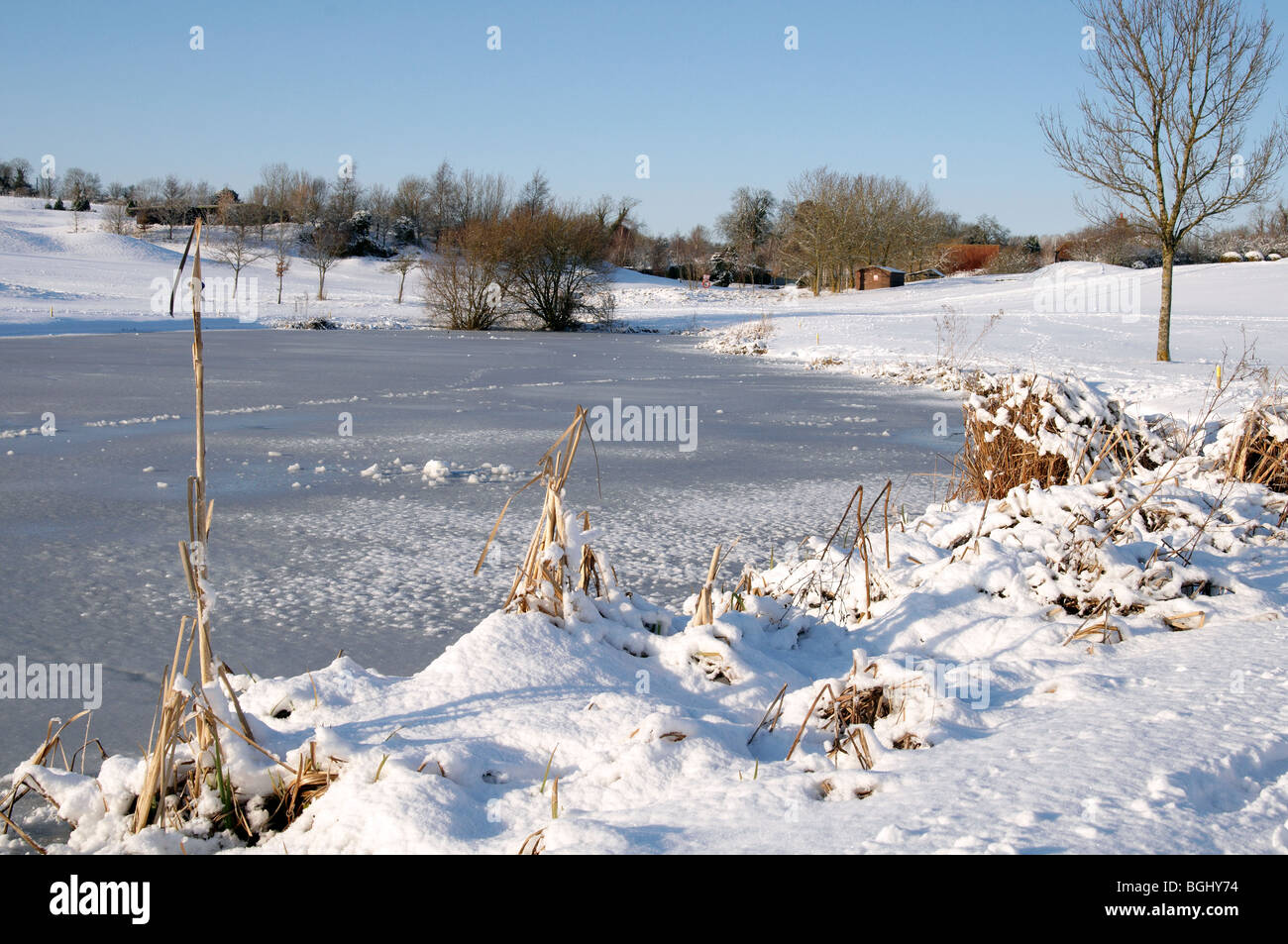 Frozen lake and snow covered landscape of a golf course in Hampshire, England during the big freeze of January 2010 Stock Photo