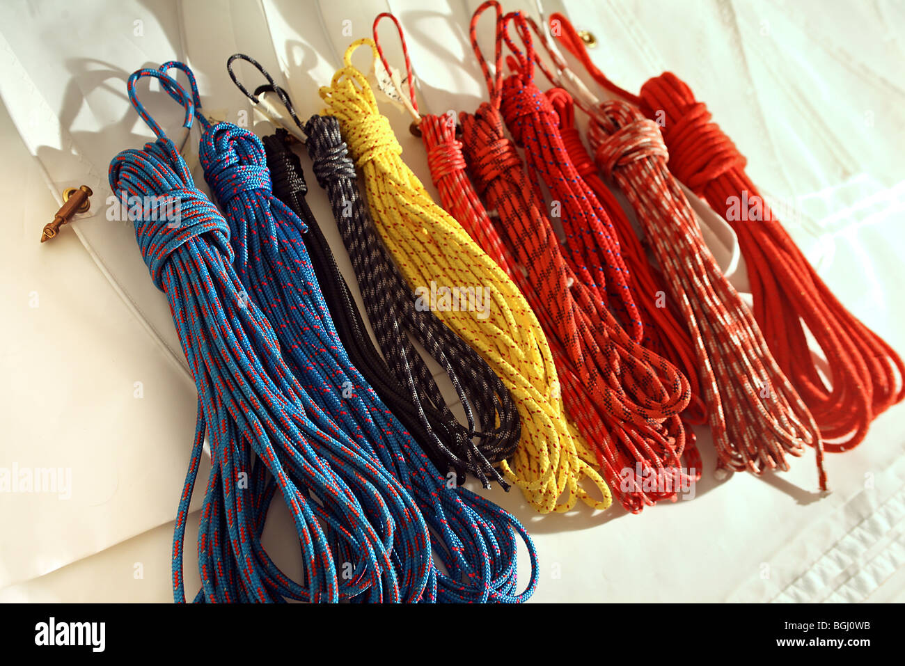 Coiled ropes, halyards, trimming and sheet lines lay on surface of