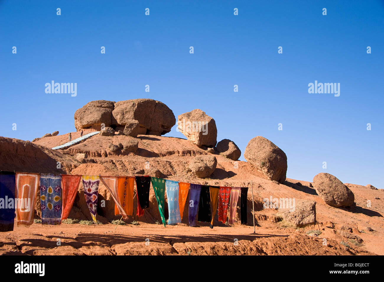 Handmade scarves drying in the sun by the strange rock formations near El Kelaa M'Gouna Morocco. Stock Photo