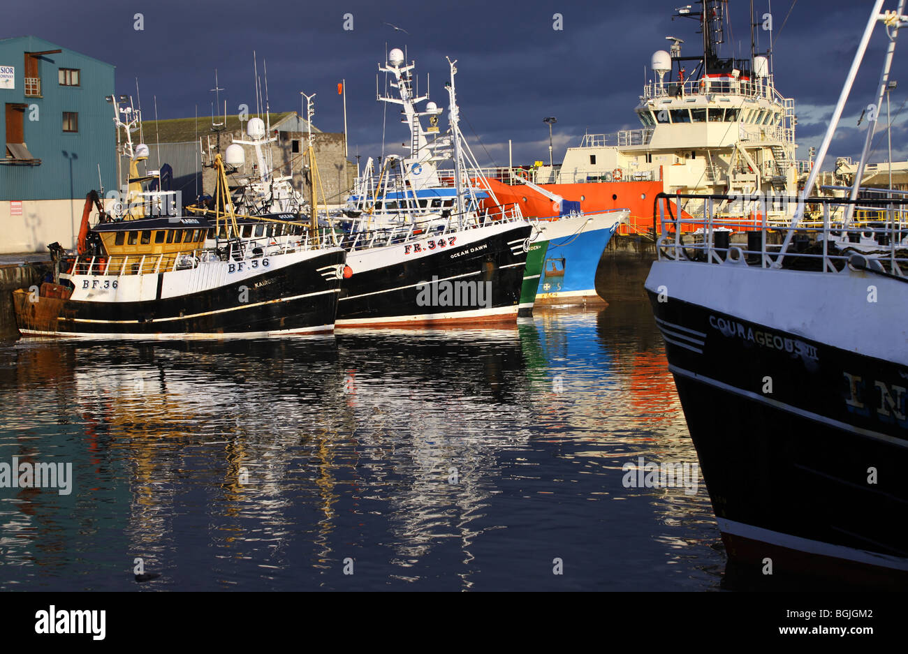 North Sea fishing trawlers berthed in Fraserburgh Harbour, Aberdeenshire, Scotland, UK, at sunset Stock Photo