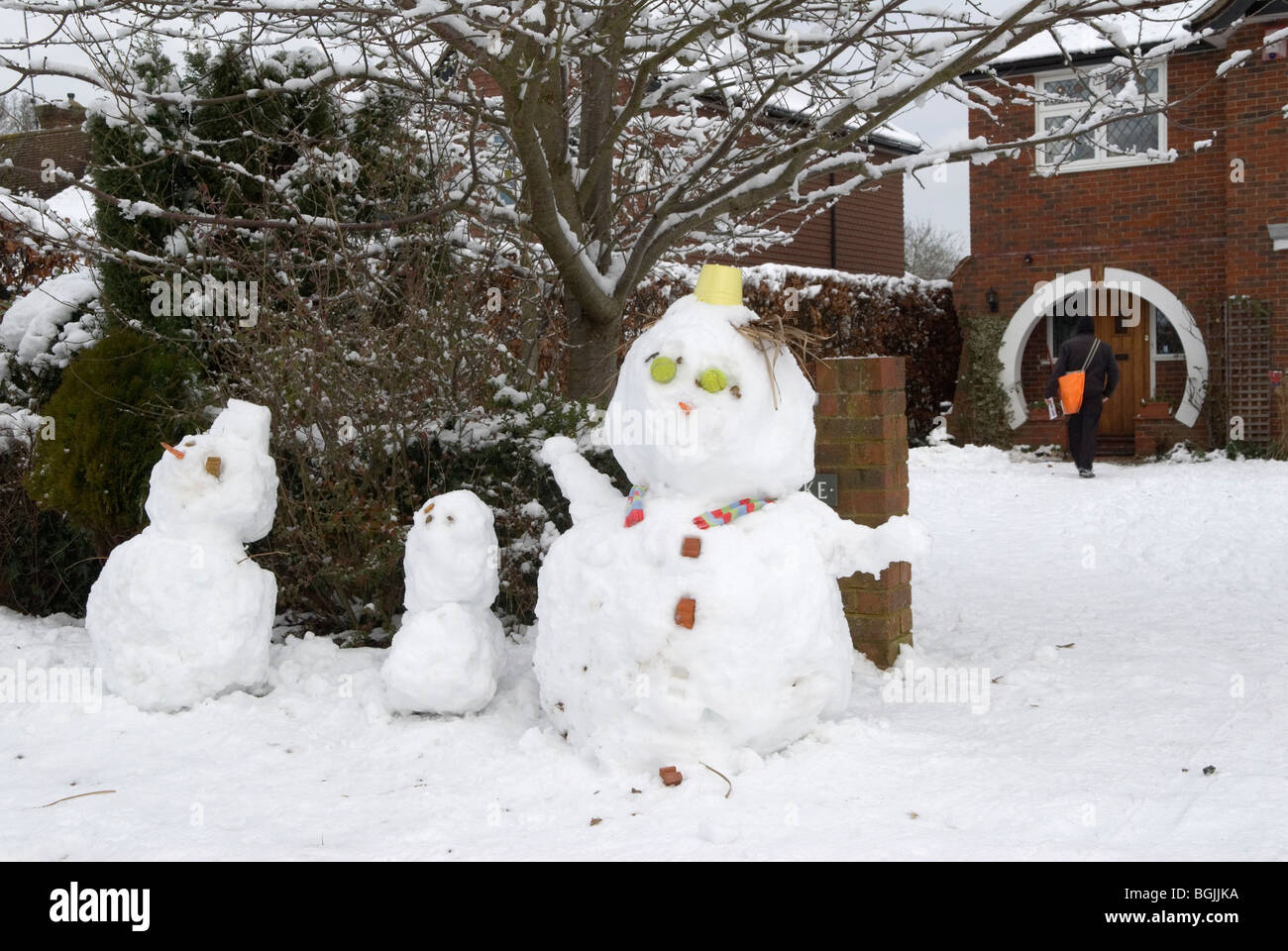 Winter weather 2010, snowmen in suburban road suburban family home heavy snow fall the night day before. Surrey England UK. 2010s HOMER SYKES Stock Photo