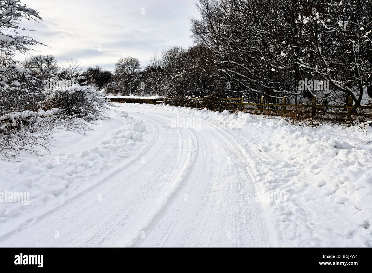 Potentially dangerous bend in a snow covered road Stock Photo