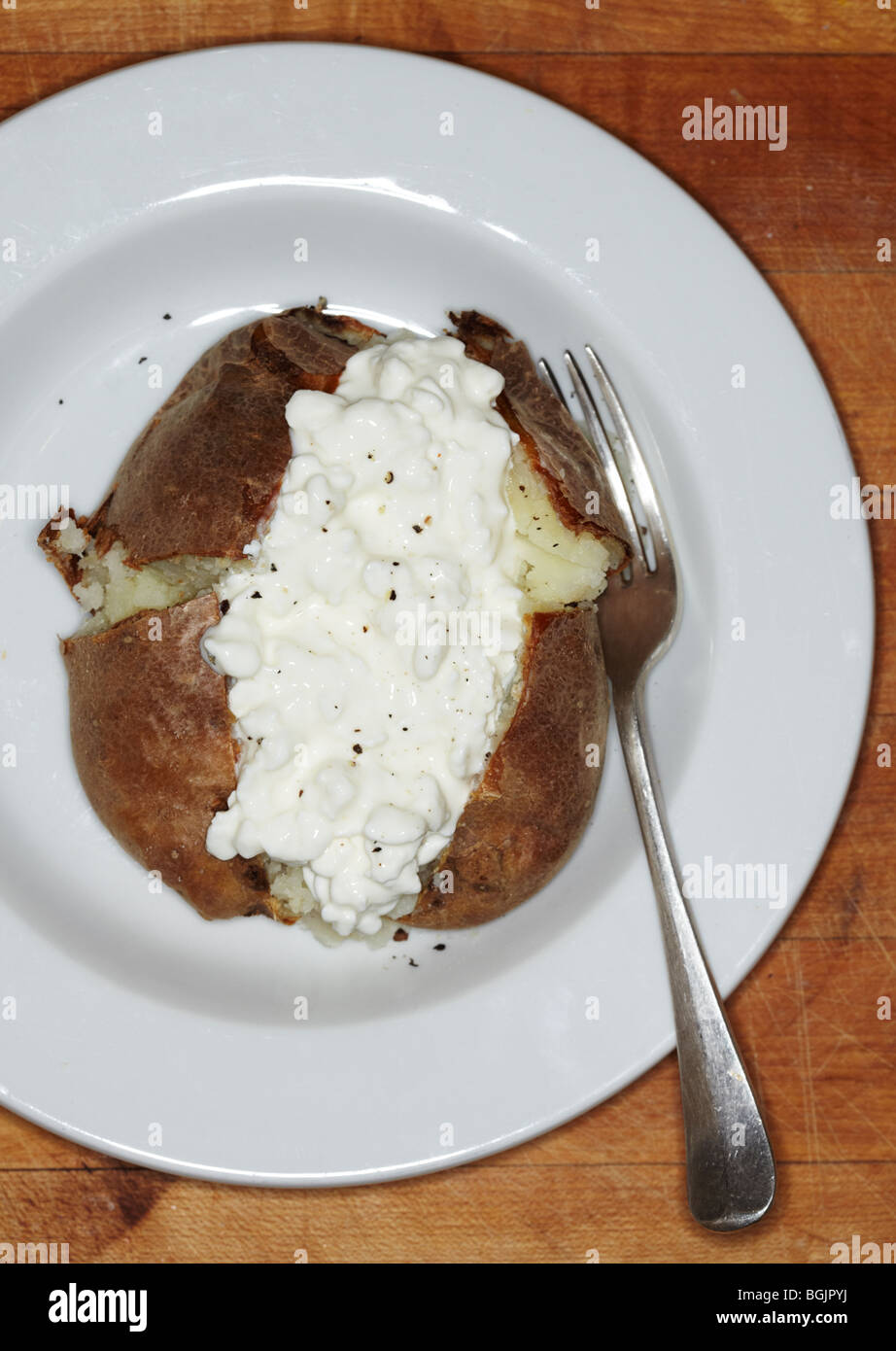 Baked Potato With Cottage Cheese On A Plate With Fork Stock Photo