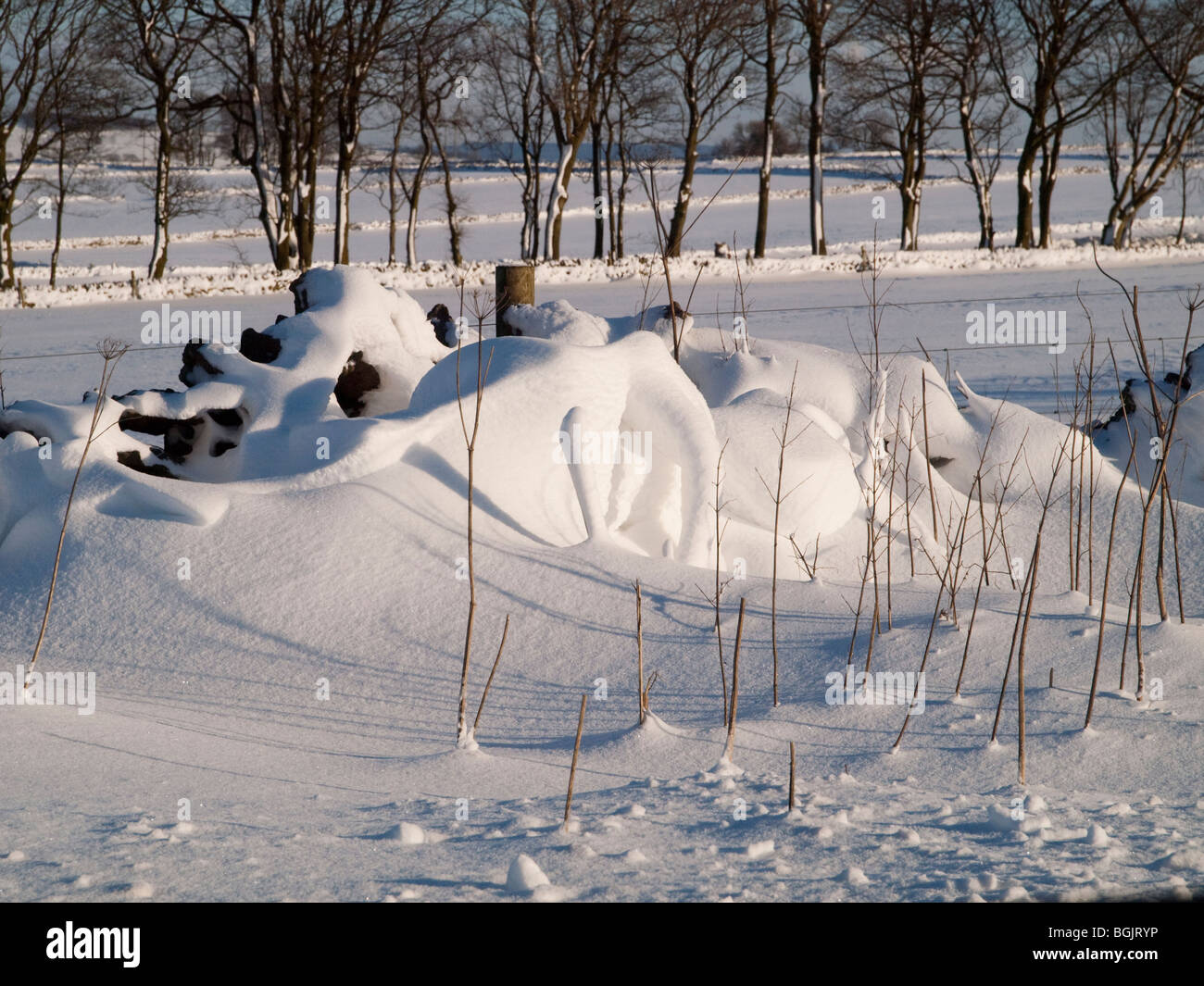 A snow drift by the A515 north of Ashbourne in the Peak District, Derbyshire England UK Stock Photo