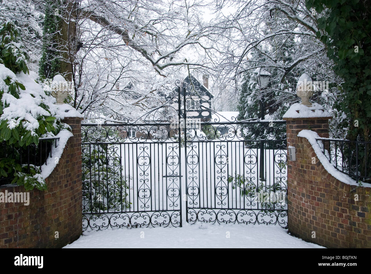 snow covered entrance wrought iron gates to detached property. Major snow fall A3 area of hampshire january 2010 Stock Photo