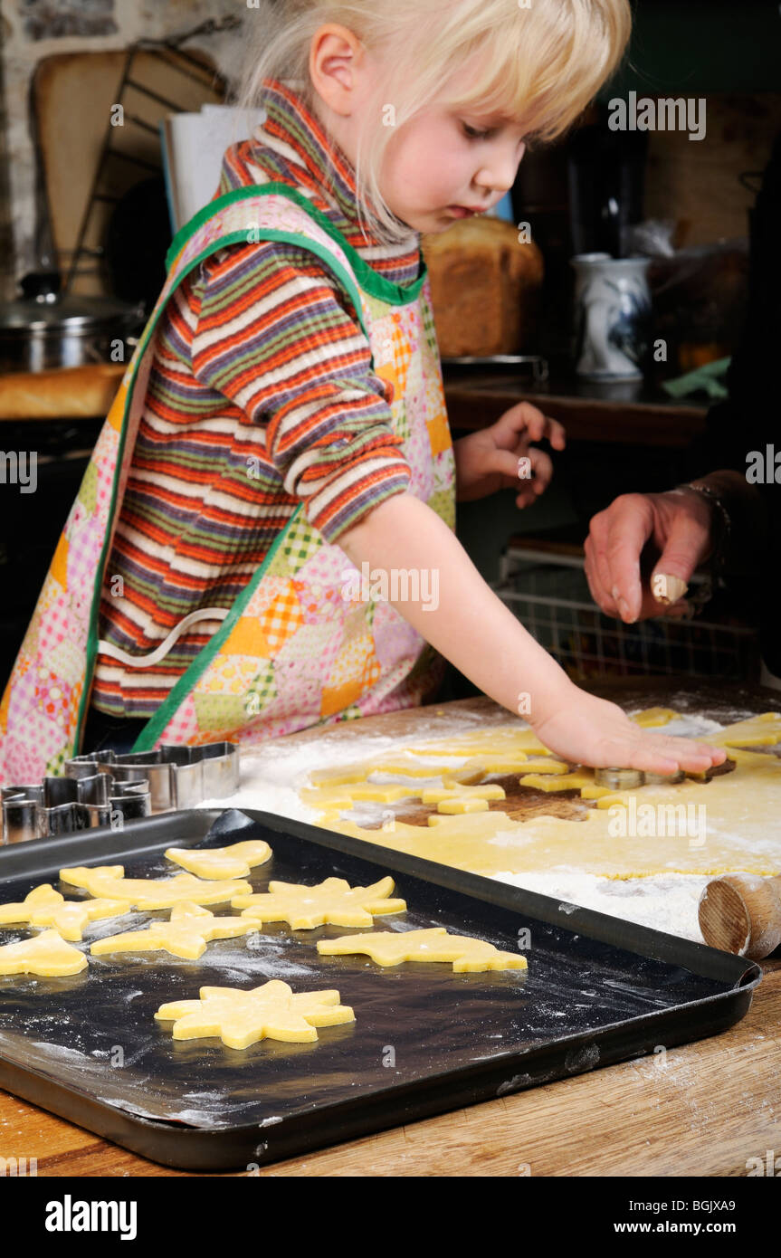 Stock photo of a four year old girl making cookies in the kitchen. Stock Photo