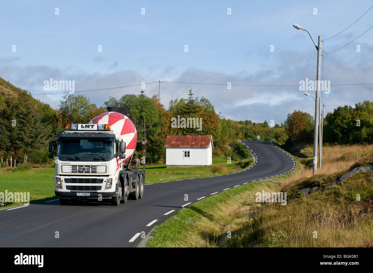 Narrow and curvy road with a large vehicle, a concrete lorry Stock Photo
