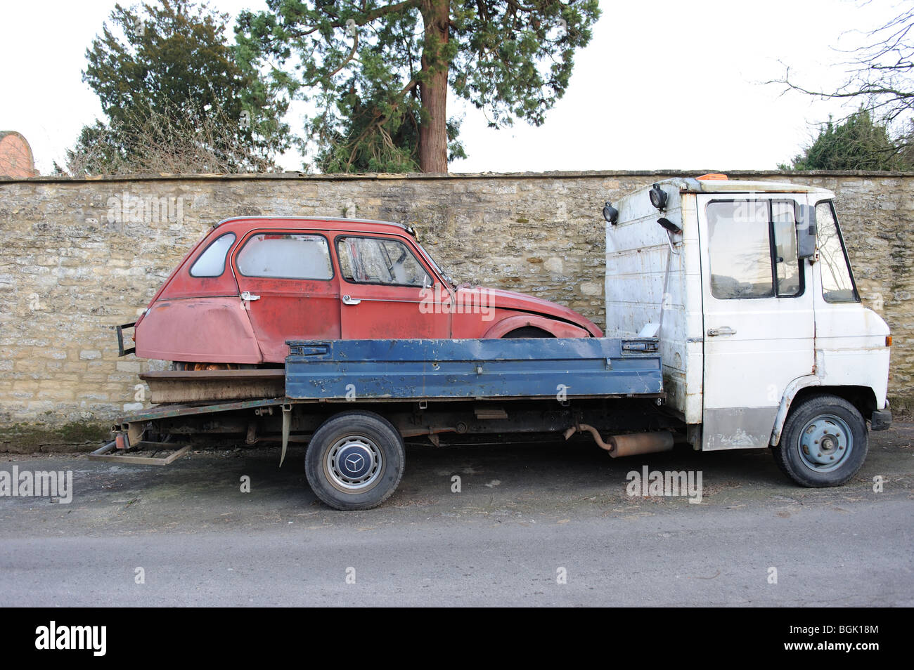 2CV Citroen old scrap metal banger abandoned breakers yard loader truck classic car renovation Stock Photo