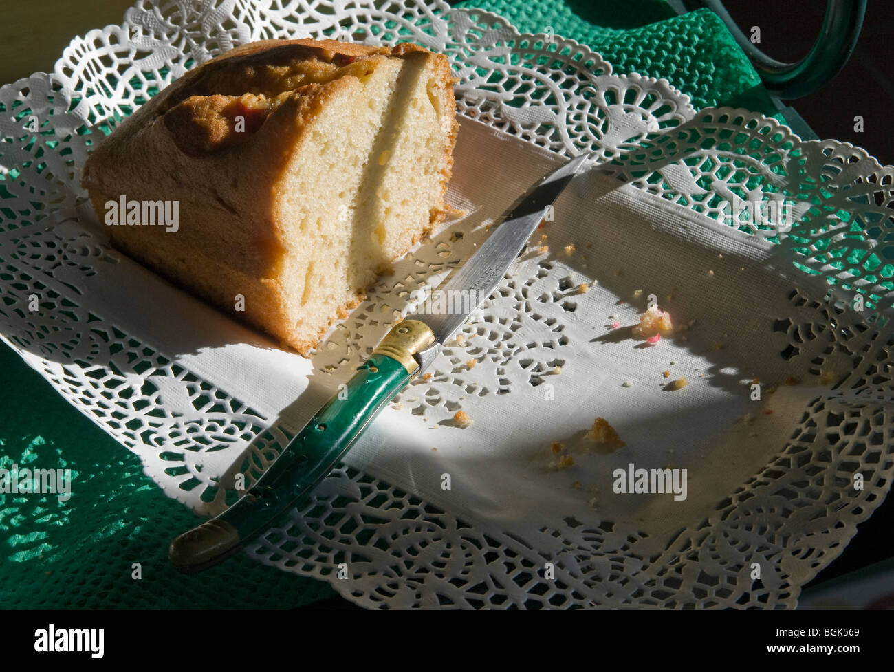 Homemade butter cake and Laguiole knife on white porcelain dish Stock Photo