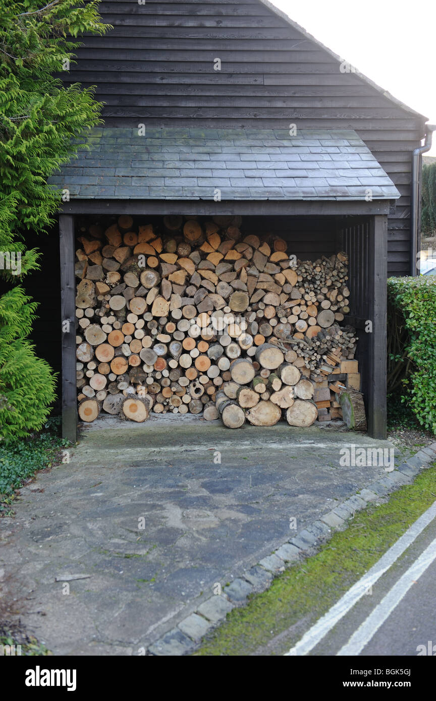 Fire wood stored woodshed stockpiled winter fuel stack stacked pile firewood logs timber Stock Photo