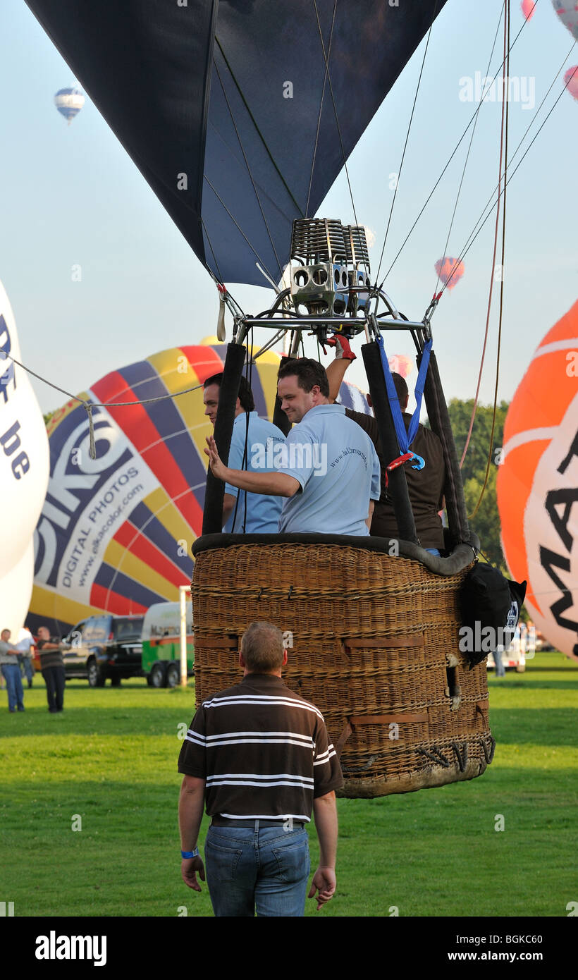 Balloonists / Aeronauts in basket of hot-air balloon taking off during ballooning meeting Stock Photo