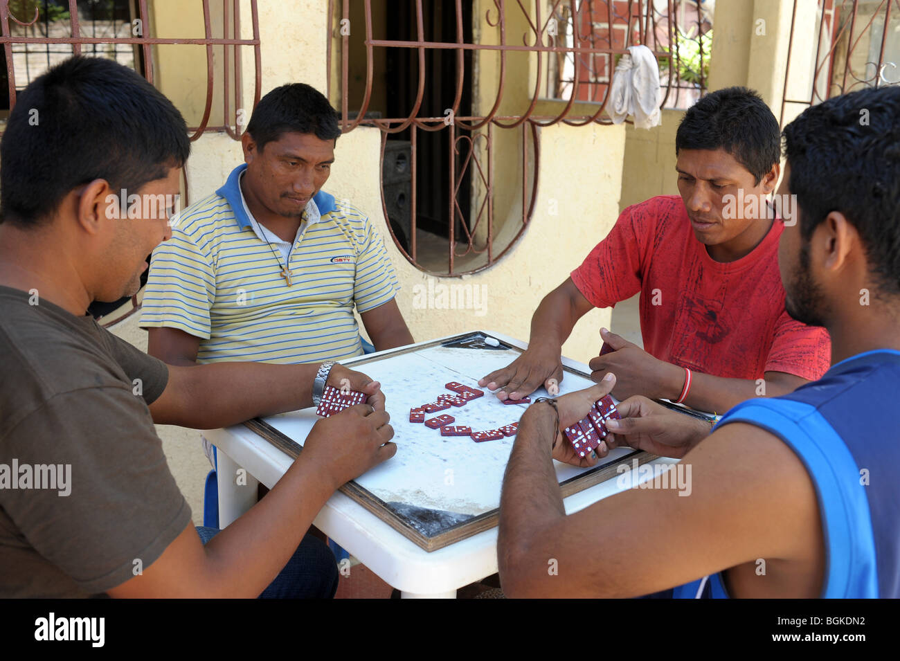 Locals playing dominoes outside in Taganga, a small fishing village on the outskirts of Tayrone National Park, Colombia Stock Photo