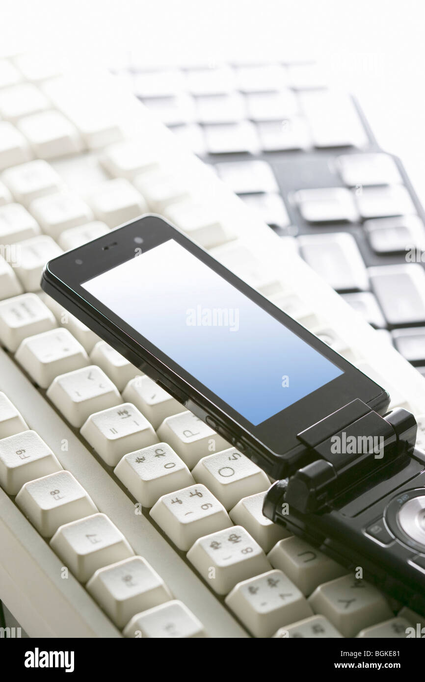Mobile phone and computer keyboards Stock Photo Alamy