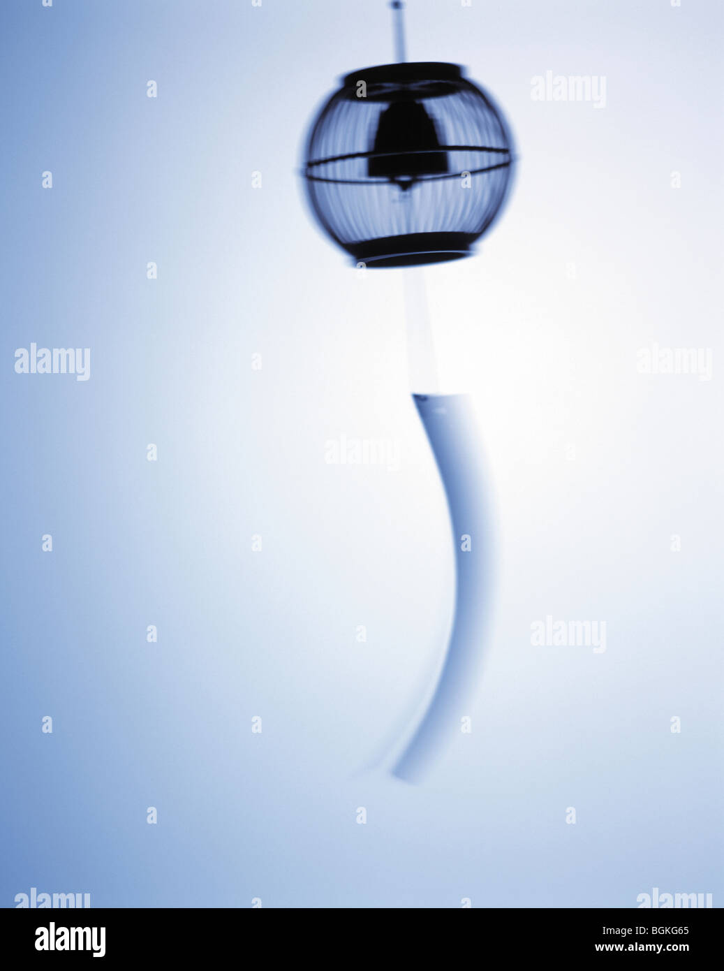 Silhouette of wind chime white background blurred motion Stock Photo