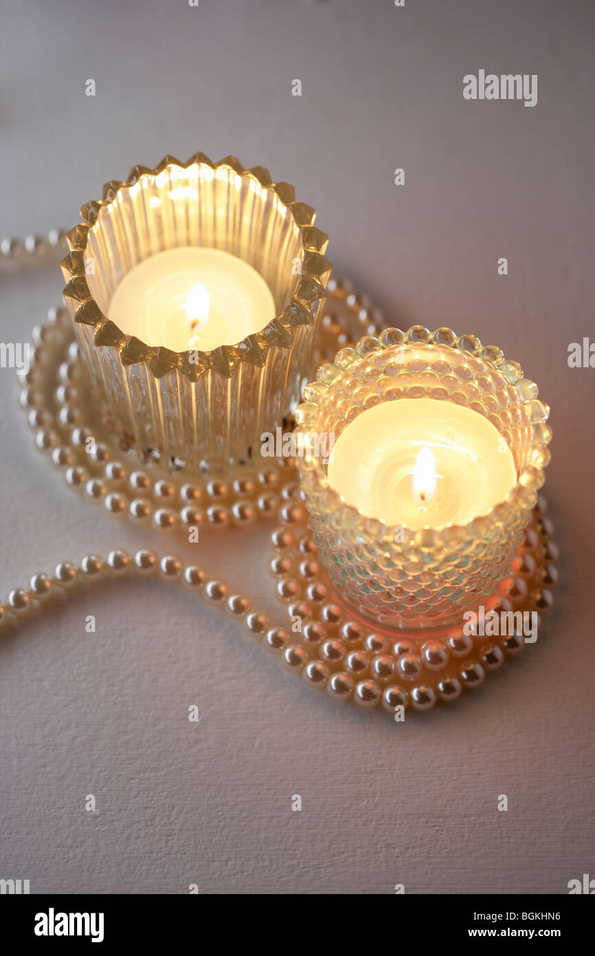Tealight candles in glass holders with pearl necklace Stock Photo Alamy