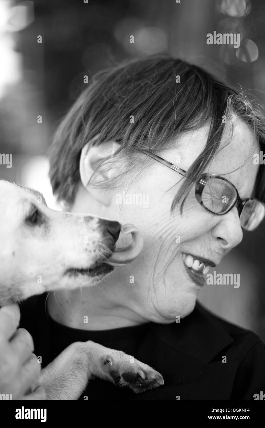 Late middle aged woman plays with dog Vauxhall South London Stock Photo