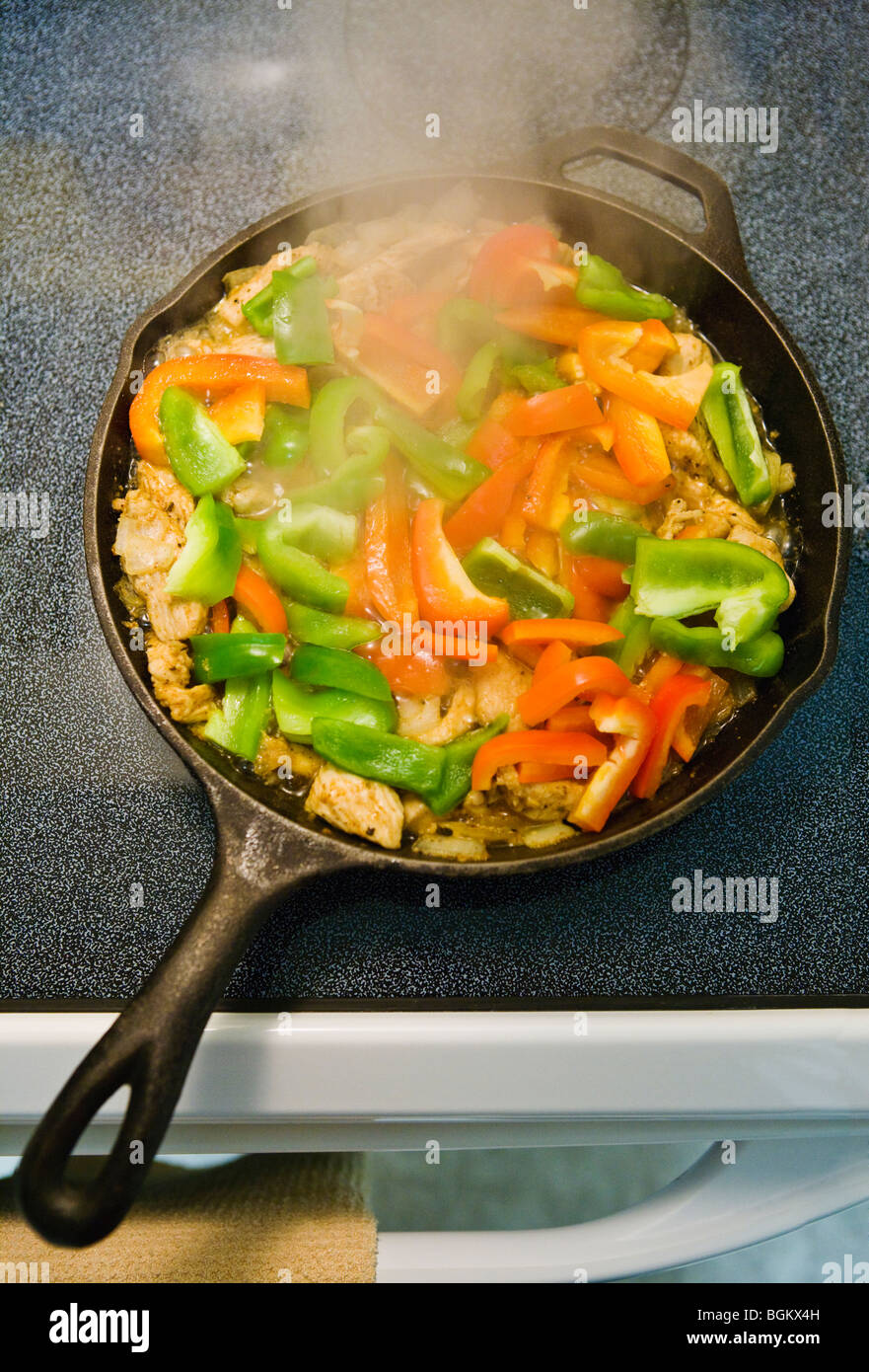 Chicken Fajitas cooking in a iron skillet on a stove top Stock Photo Alamy