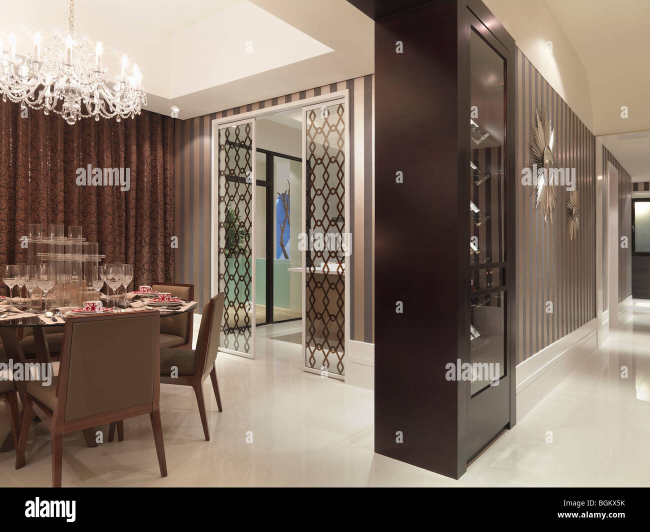 Elegant dining room with chandelier and printed wall paper Stock Photo