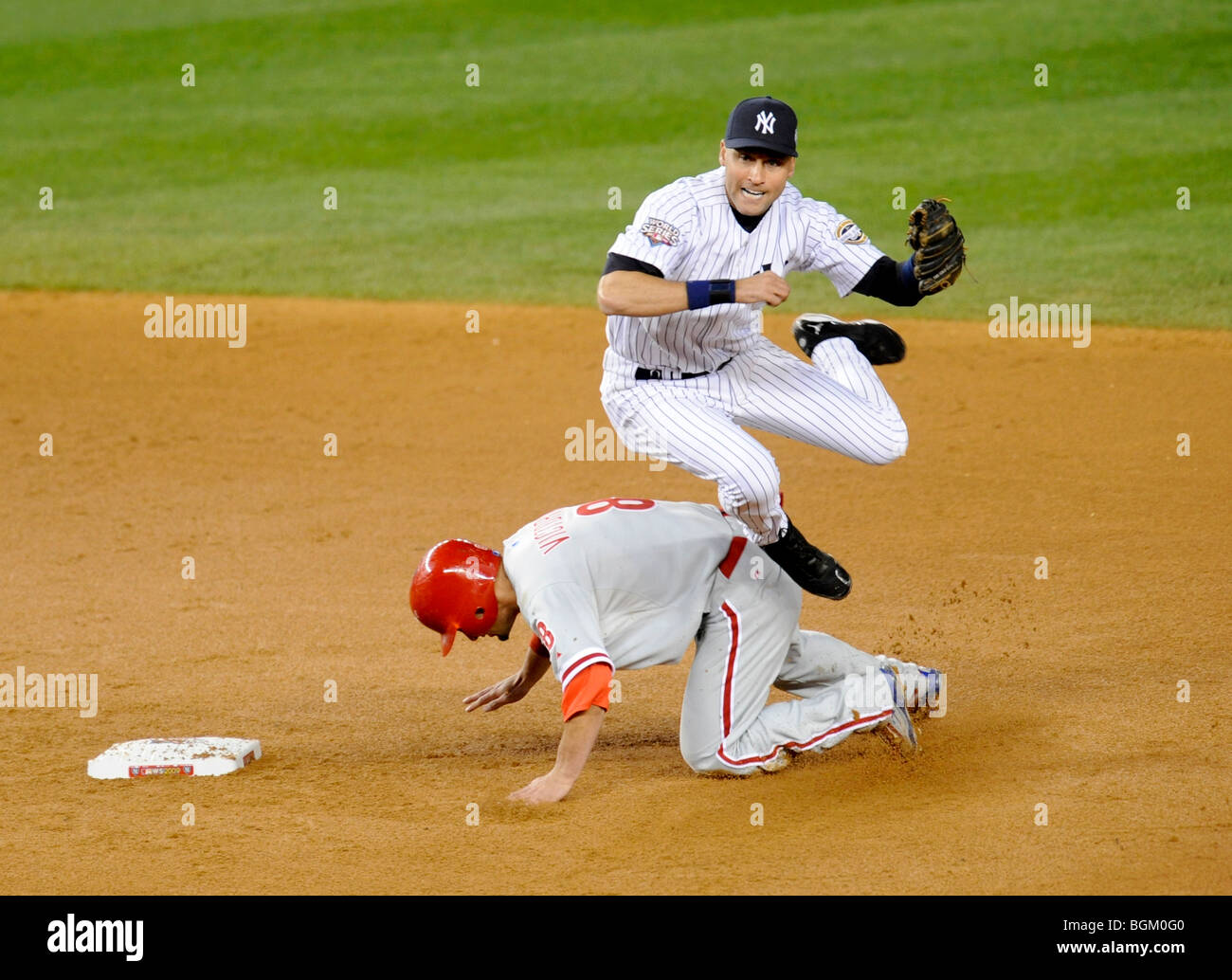 Derek Jeter #2 of the New York Yankees completes the double play as Shane Victorino #8 of the Philadelphia Phillies slides into Stock Photo