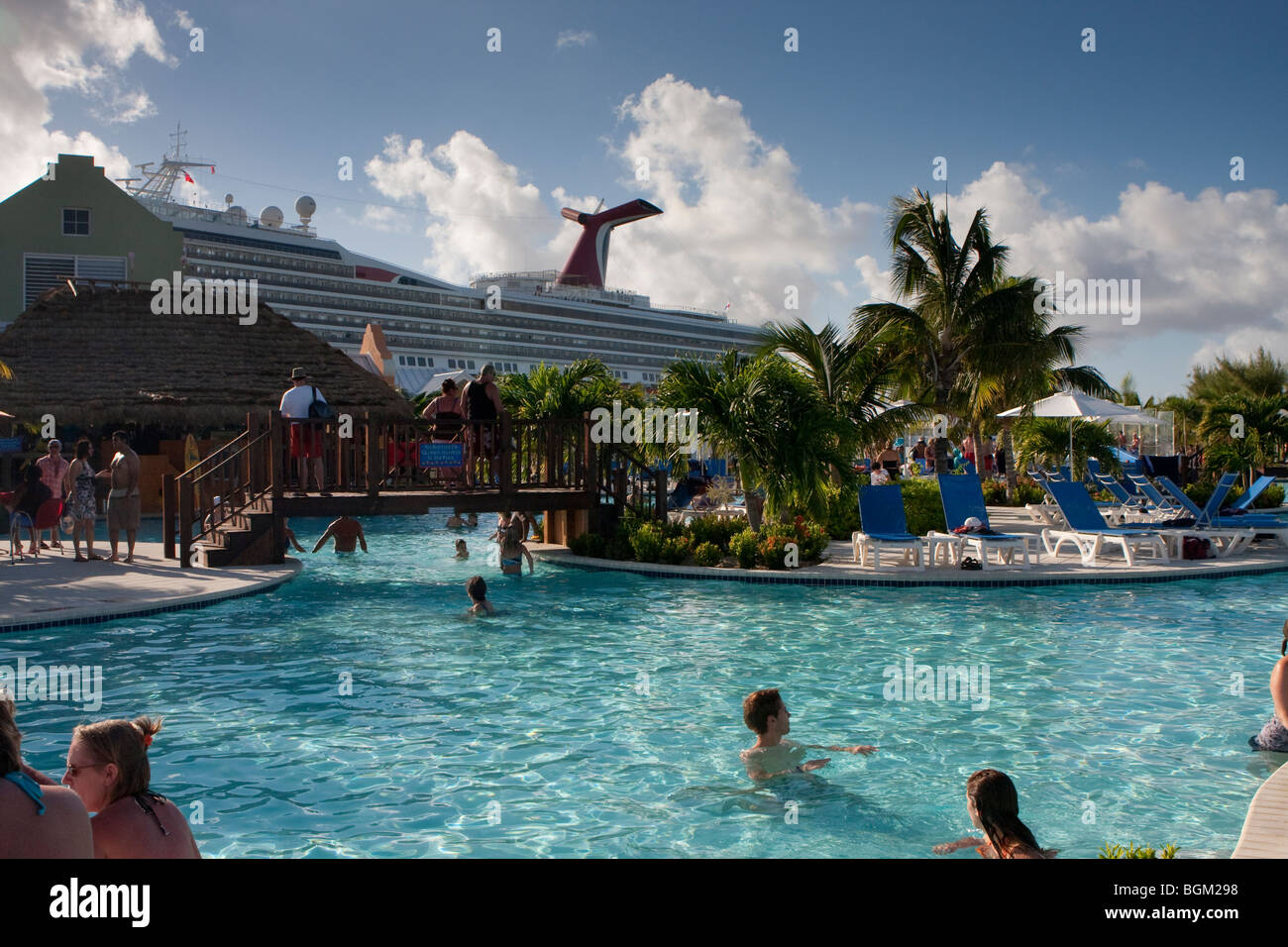 Cruise port, Grand Turk Island, Margaritaville pool, with puffy clouds, and Carnival cruise ship in background.  BWI Stock Photo