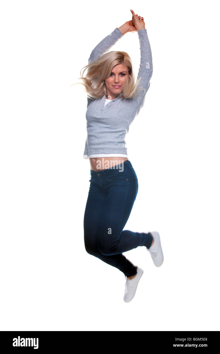 A pretty young blond woman jumping in the air, isolated on a white background. Slight motion blur. Stock Photo