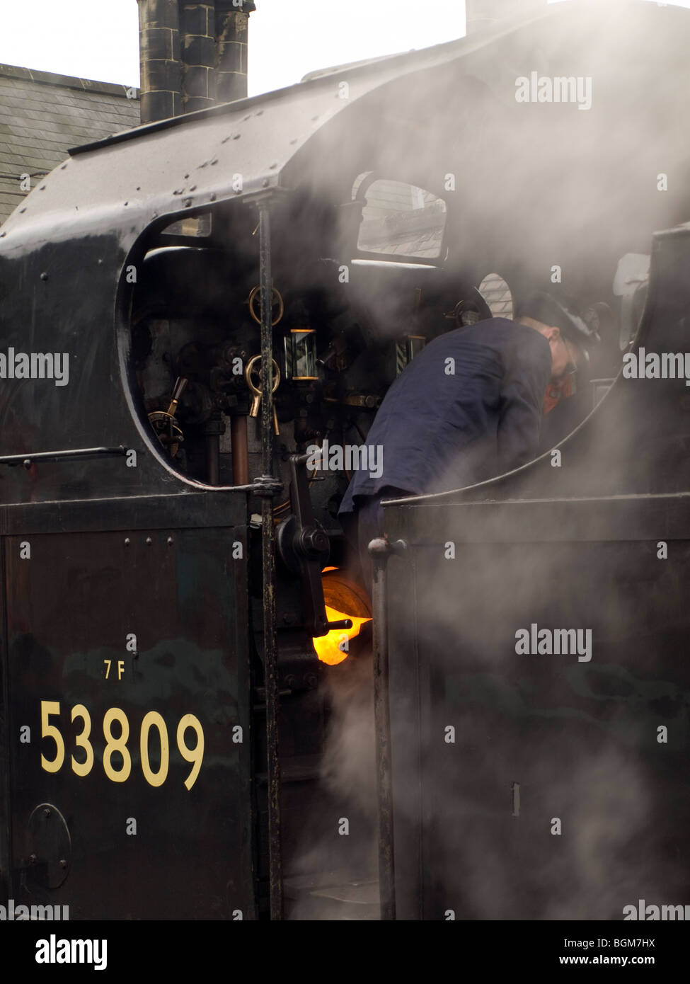 Fireman on Steam Train stoking the boiler. North York Moors Railway. Stock Photo