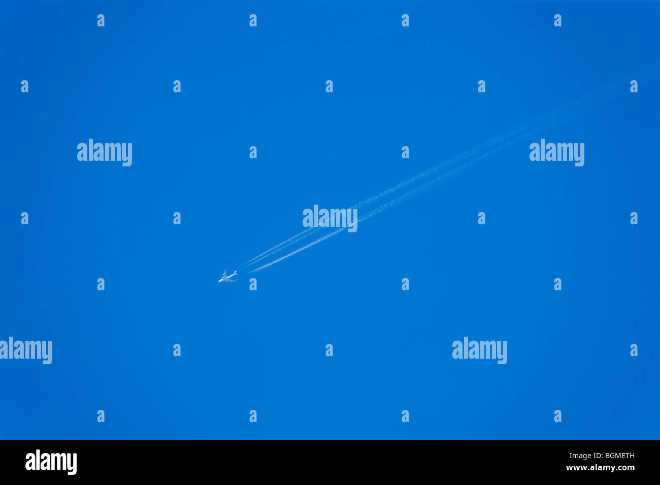 An Airplane in a Blue Sky Stock Photo - Alamy