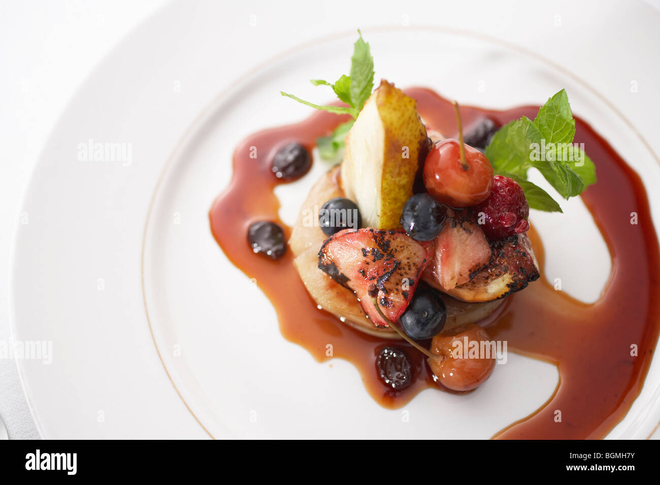 Oven roasted fruit with berry compote Stock Photo