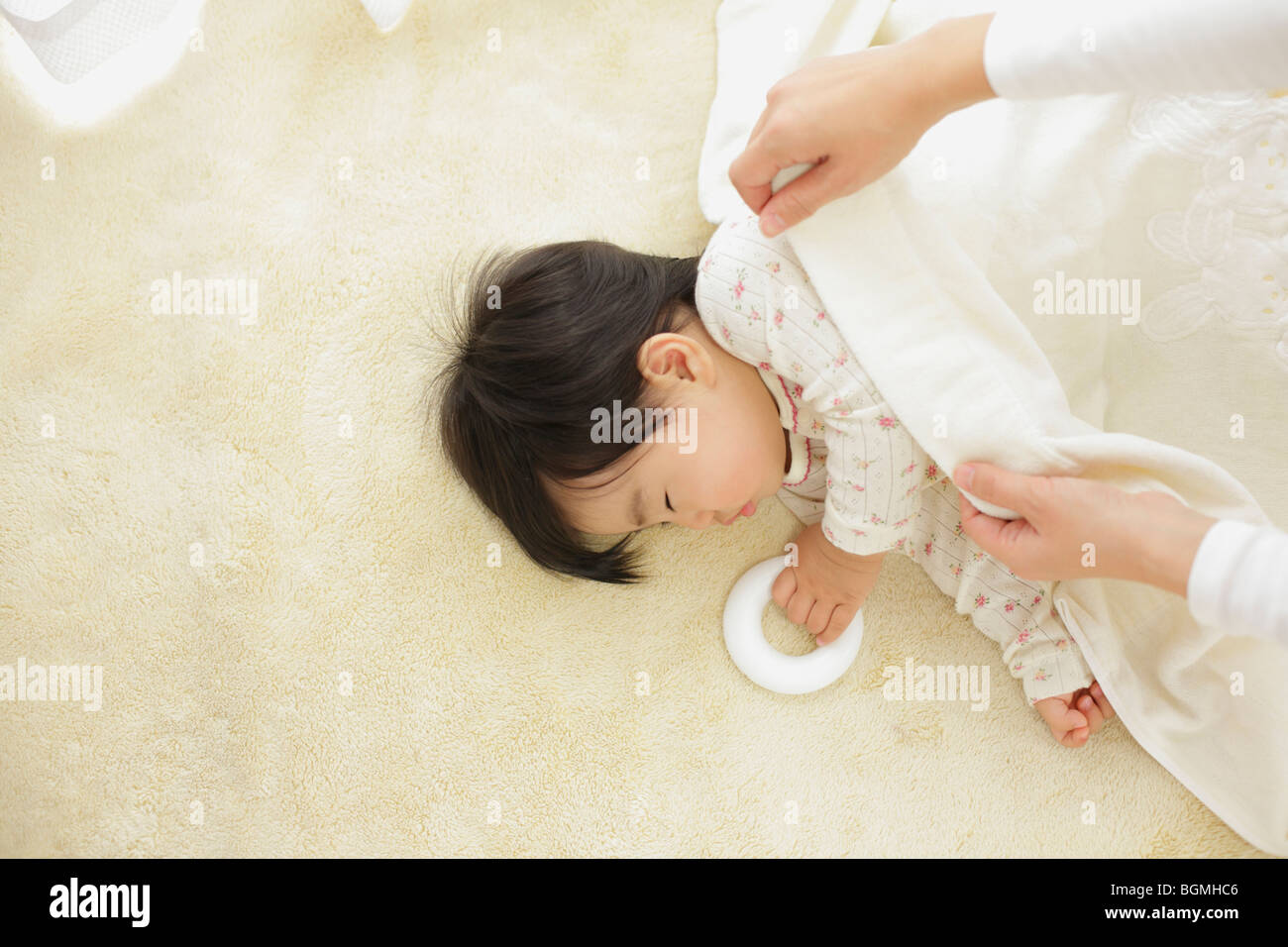 Mother covering sleeping baby with blanket Stock Photo Alamy