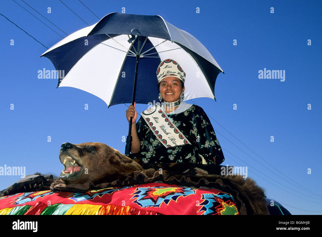 Miss Uintah River High, dressed in traditional regalia with an umbrella