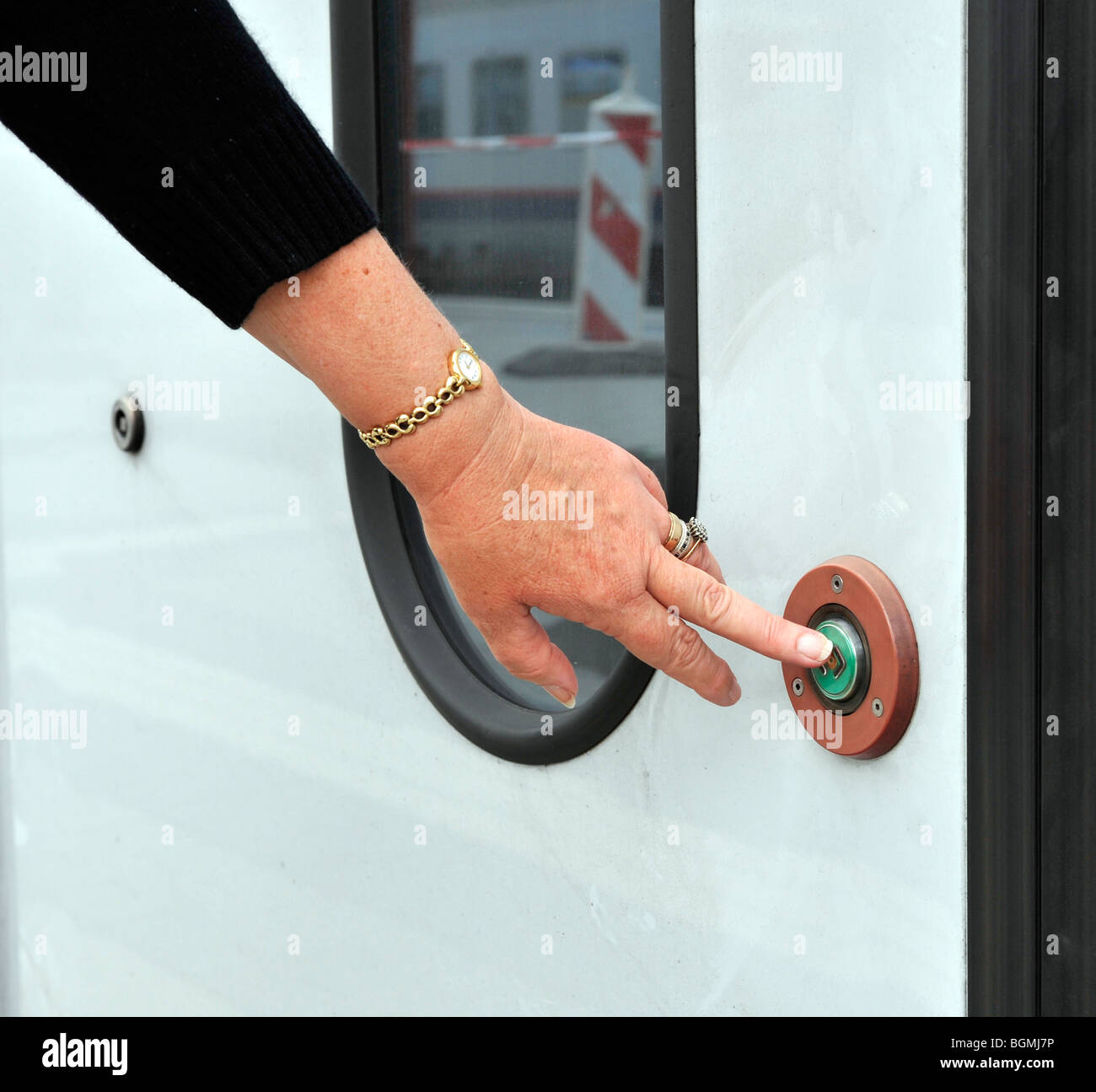 European woman pressing the door release on Luxembourg commuter train. Stock Photo
