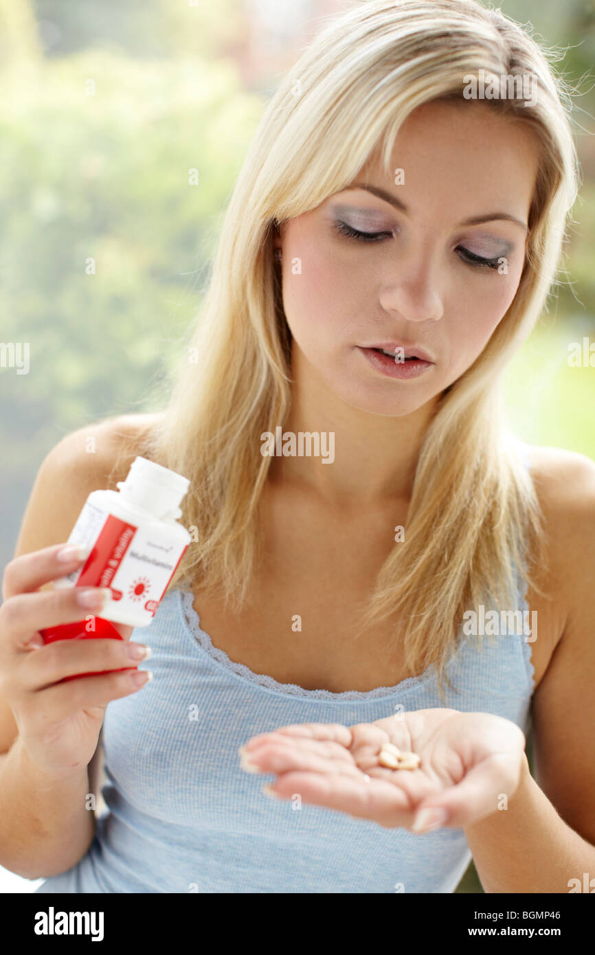 Girl taking vitamin tablets Stock Photo
