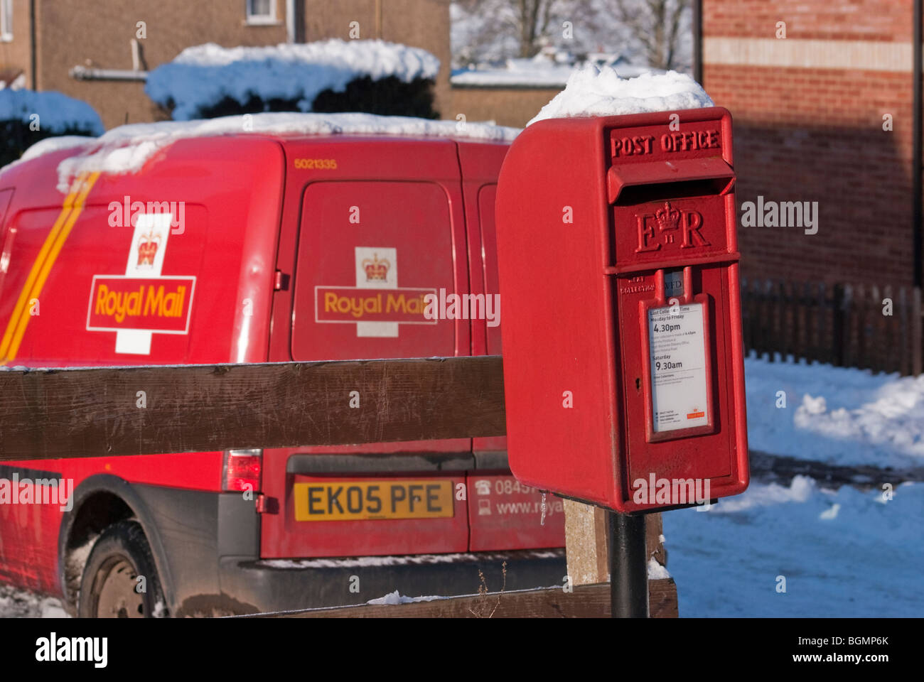 A Royal Mail delivery van parked next to a snow topped Queen Elizabeth II Lamp Box, Buckinghamshire, England, United Kingdom. Stock Photo