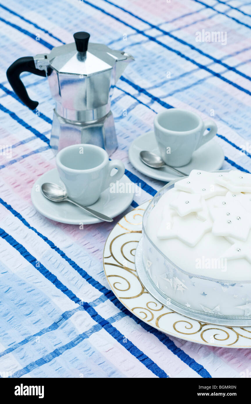 Christmas cake, espresso maker with espresso cups and saucers on a