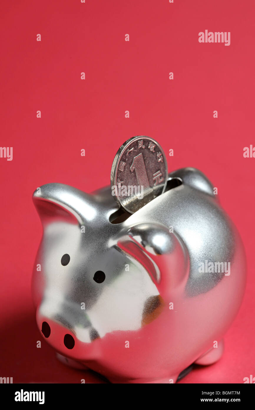Silver piggy bank with Chinese coin Stock Photo