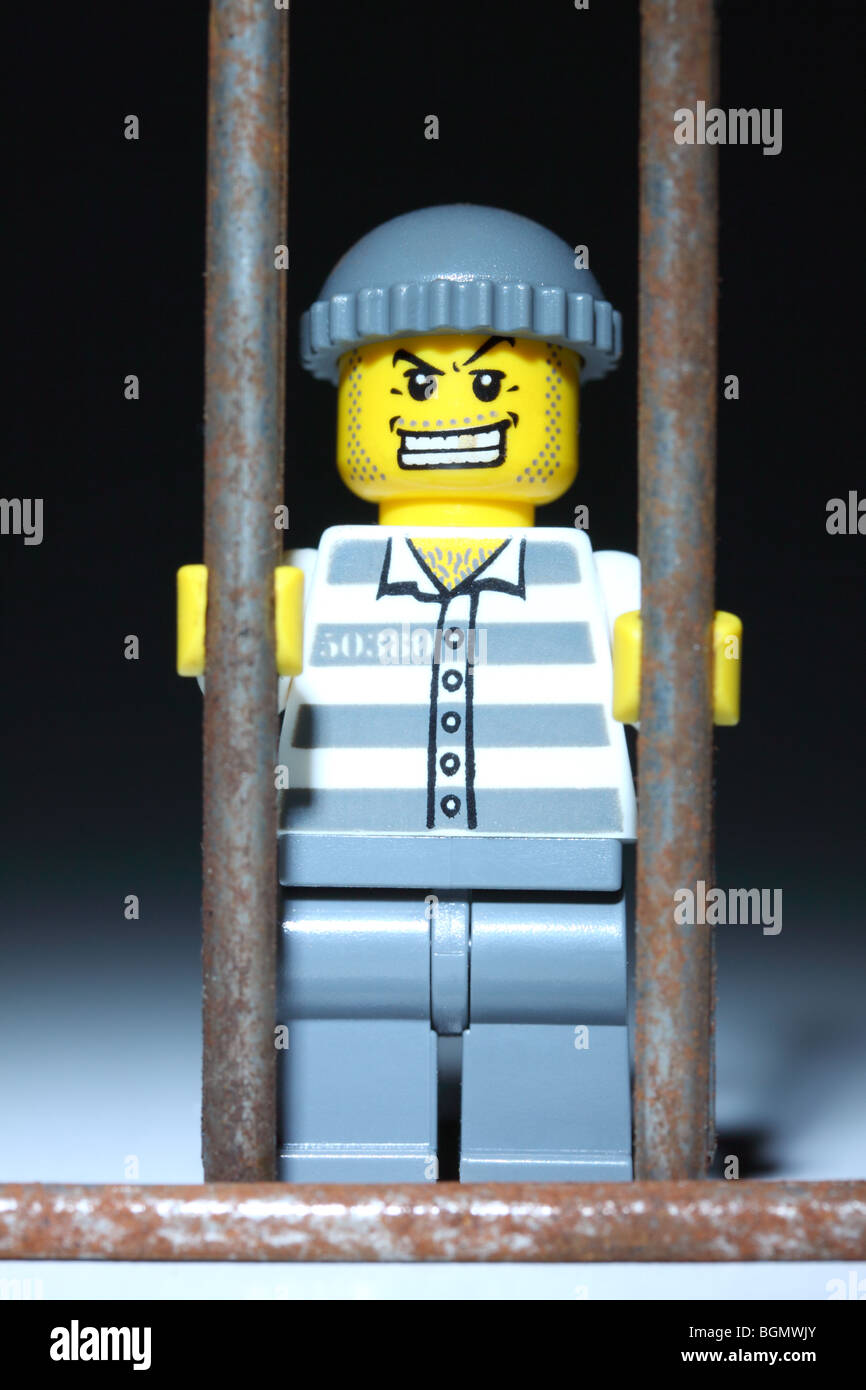 Lego prisoner behind bars Stock Photo