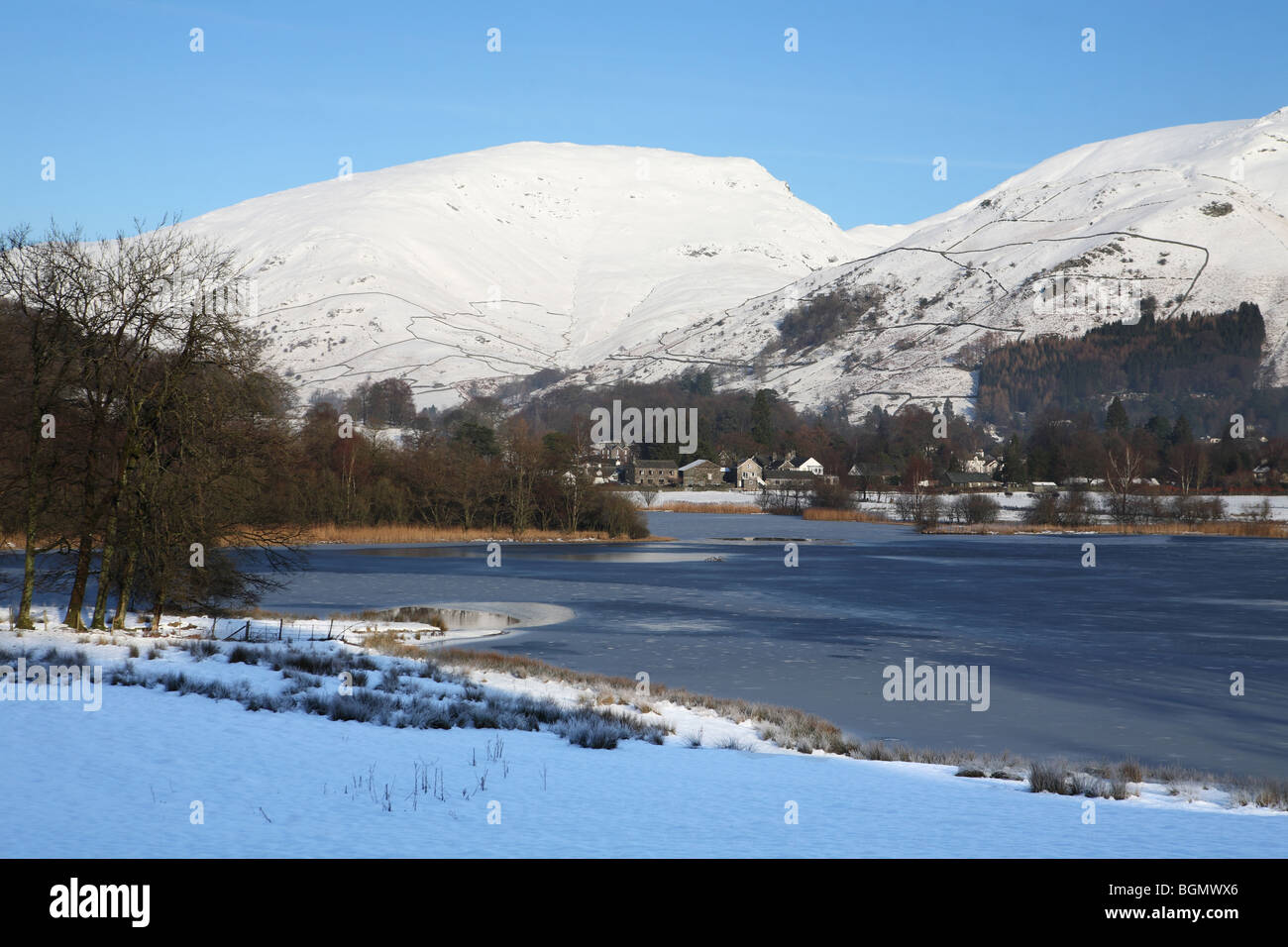 Grasmere with snow clad mountains reflected in the lake, Cumbria, UK Stock Photo