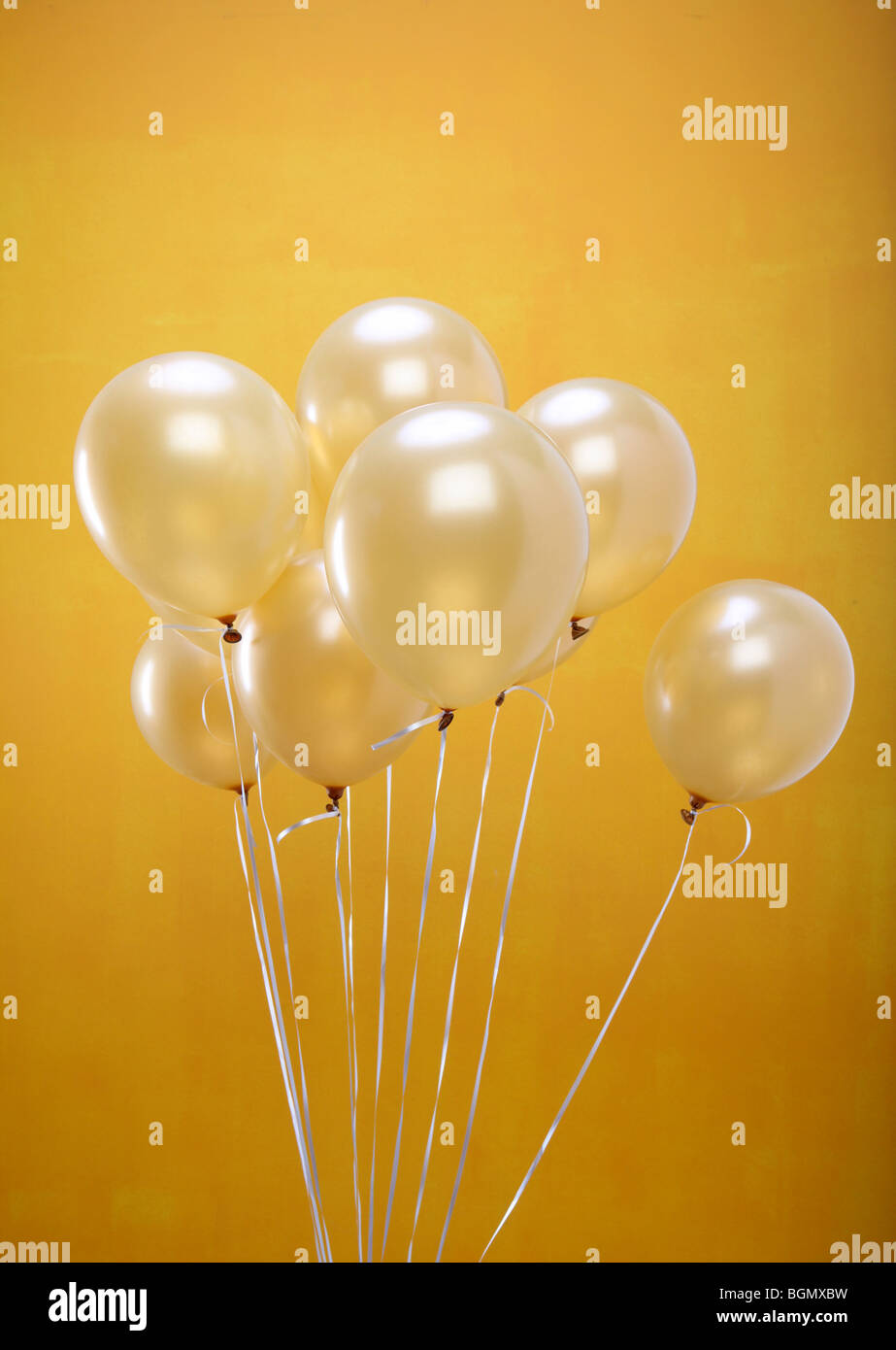 gold balloons yellow wall Stock Photo