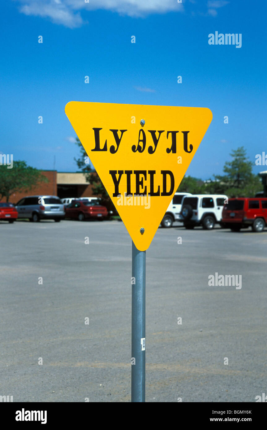 Here is a sample of Cherokee language posted on a yield sign in the Cherokee town of Tahlequay Oklahoma Stock Photo