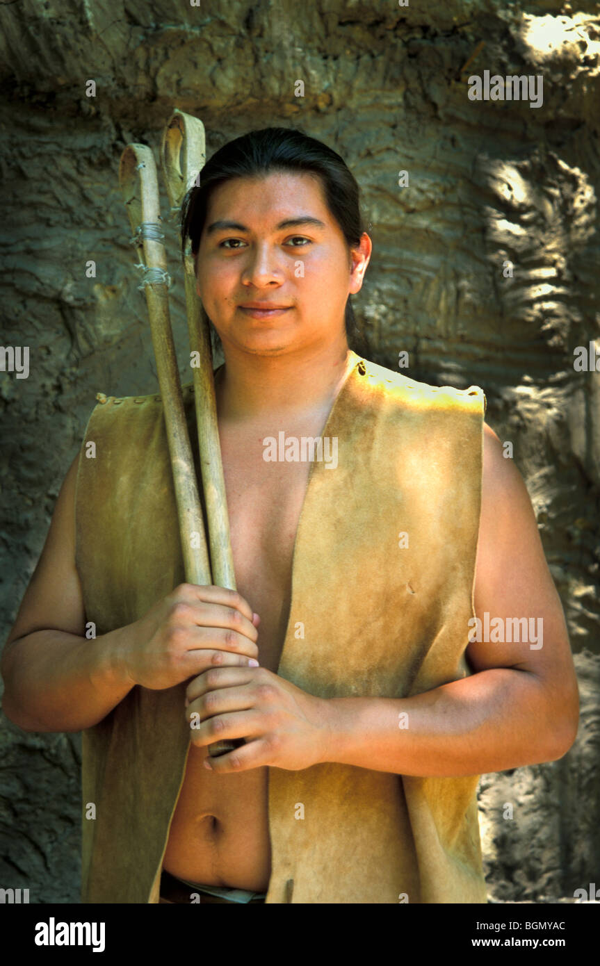 Cherokee man dressed in traditional deerhide clothing holds a pair of stickball game sticks, Tahlequay OK. Stock Photo