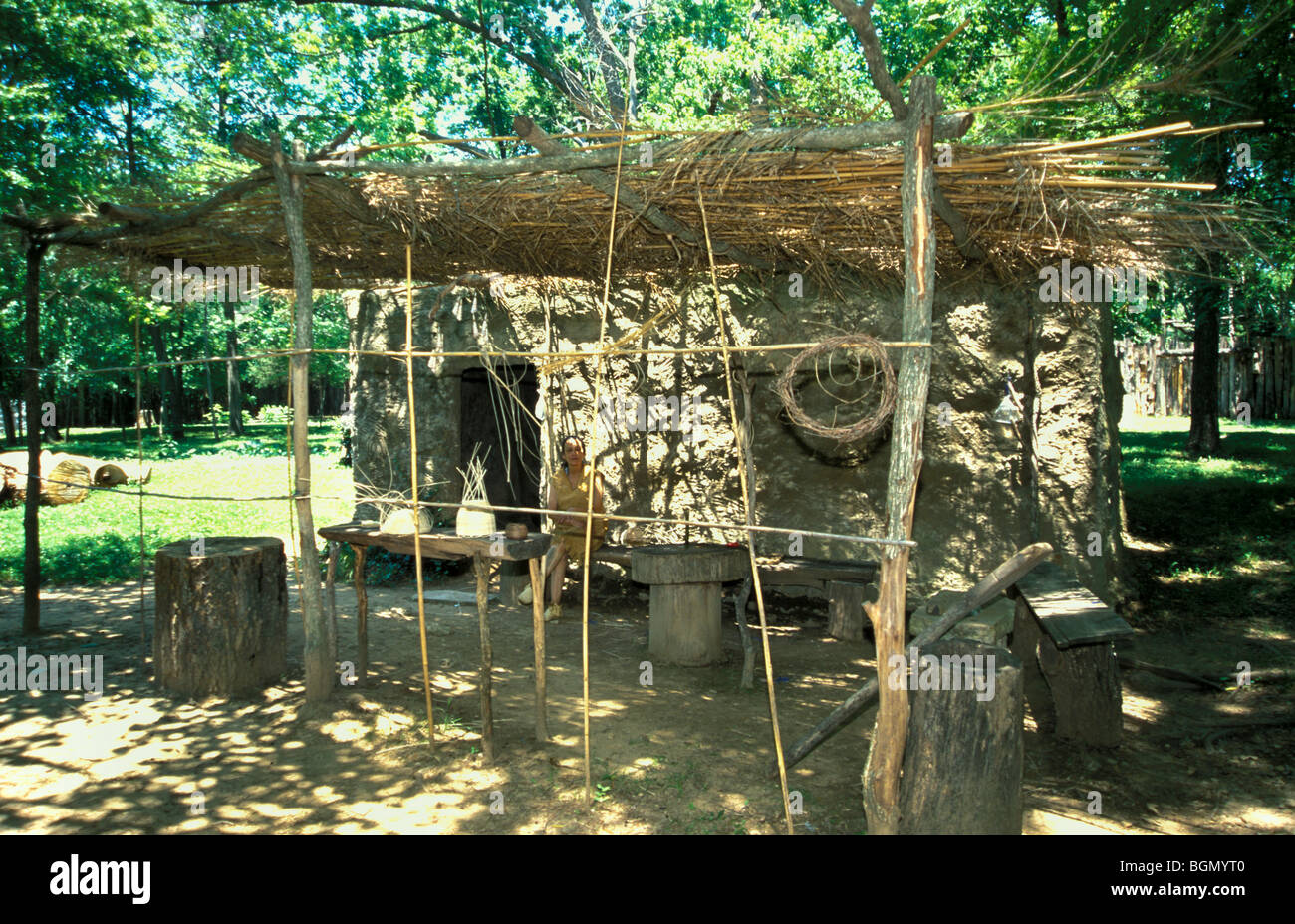 Wattle-and-daub traditional house and covered area on display at the Cherokee National Museum Indian Village, Tahlequay, OK. Stock Photo