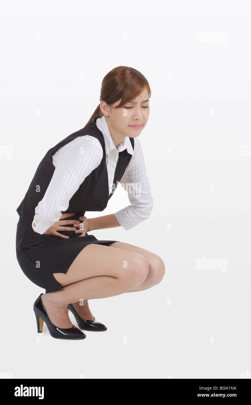 Young office lady crouching and frowning Stock Photo - Alamy