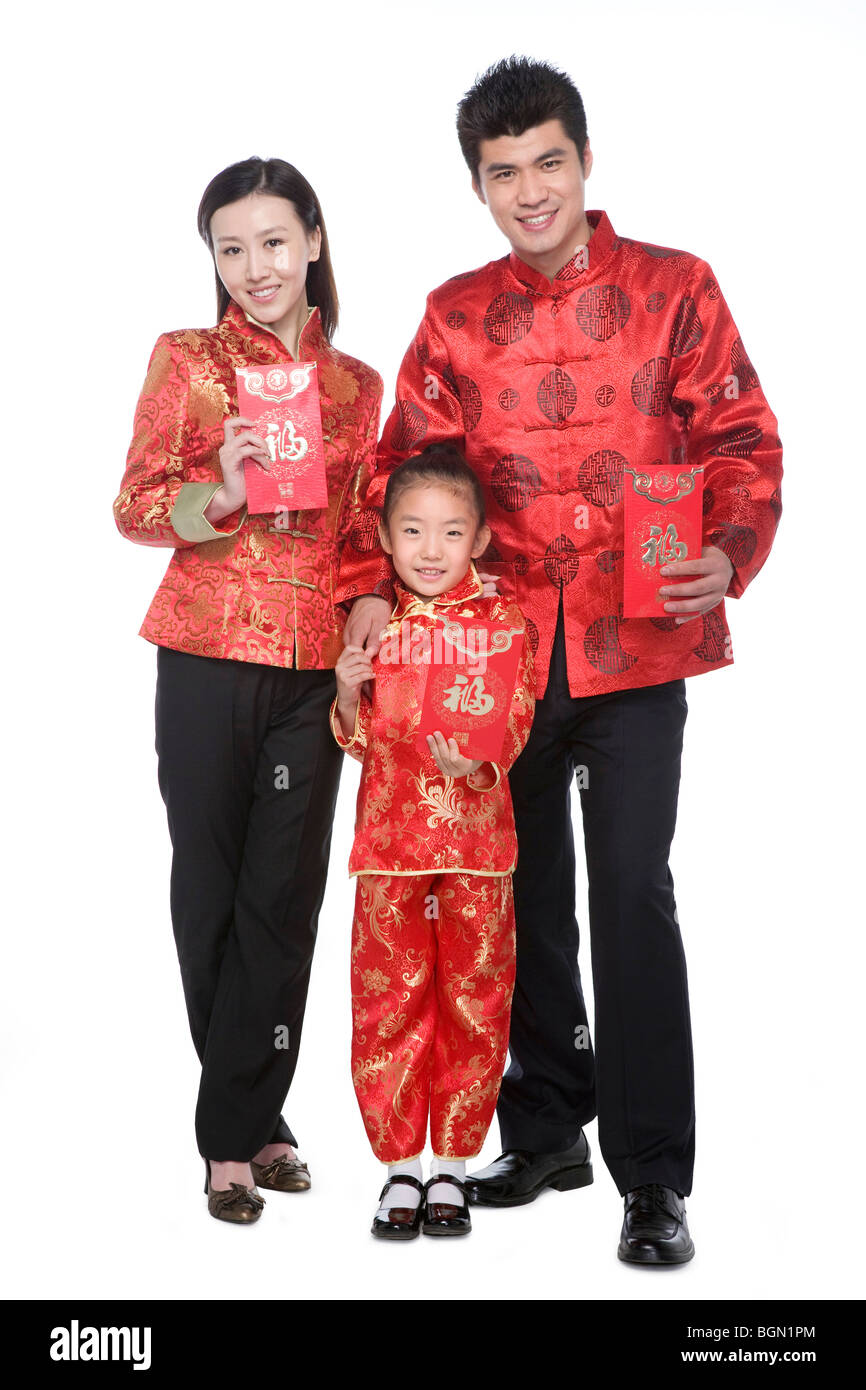 Family of three in Chinese traditional clothes holding red envelopes Stock Photo