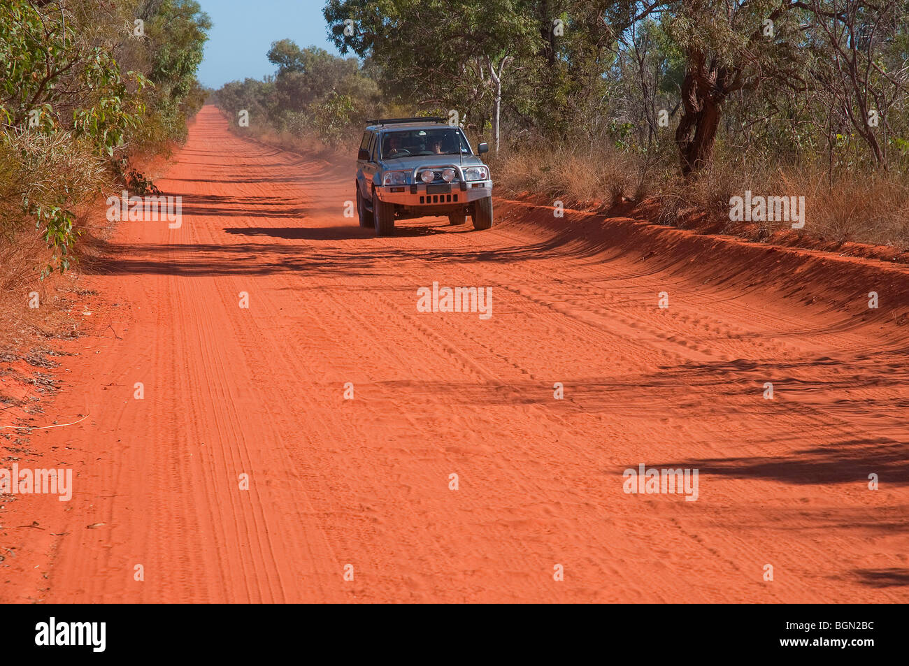Four wheel drive vehicle on the red dirt of an unsealed outback road near Broome in the Kimberley in north-west Western Australia Stock Photo