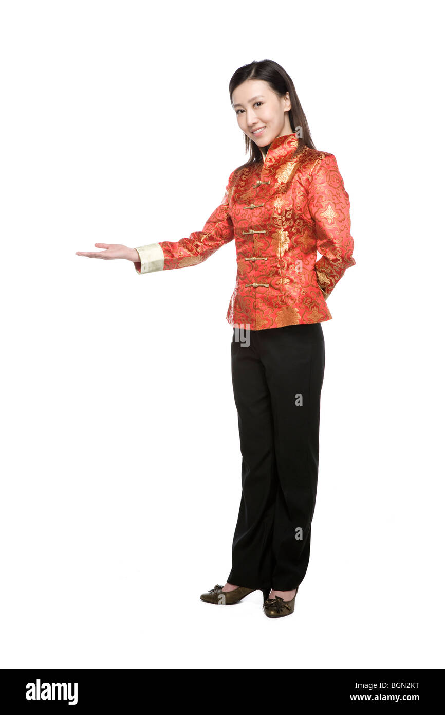 Young woman in Chinese traditional clothes doing welcoming gesture