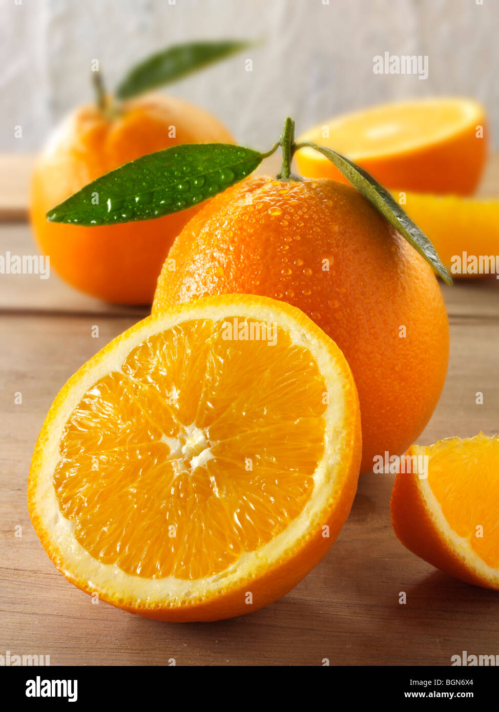 Fresh oranges whole and cut halves with leaves Stock Photo