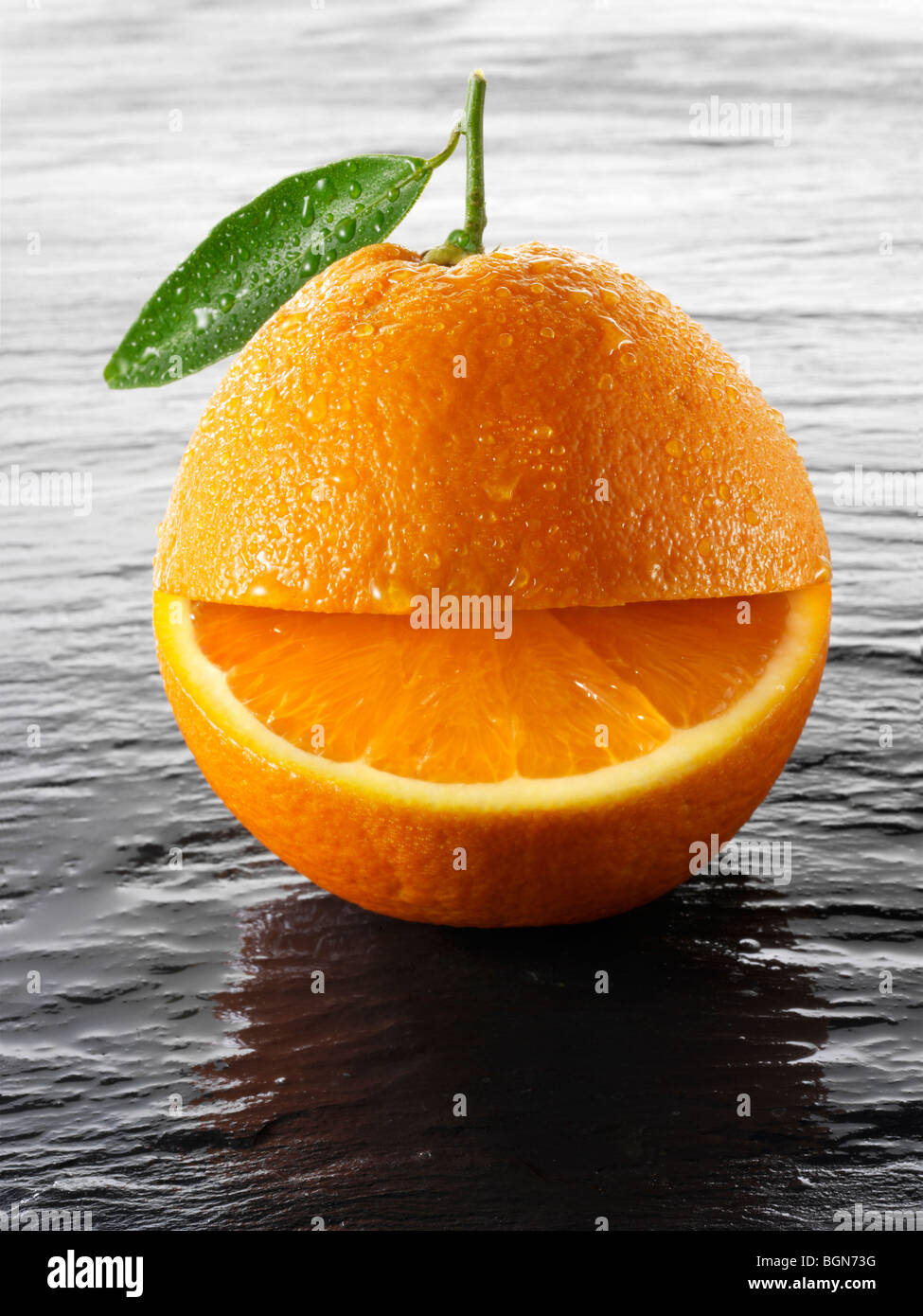Wole oranges with a smiley face on a black background Stock Photo