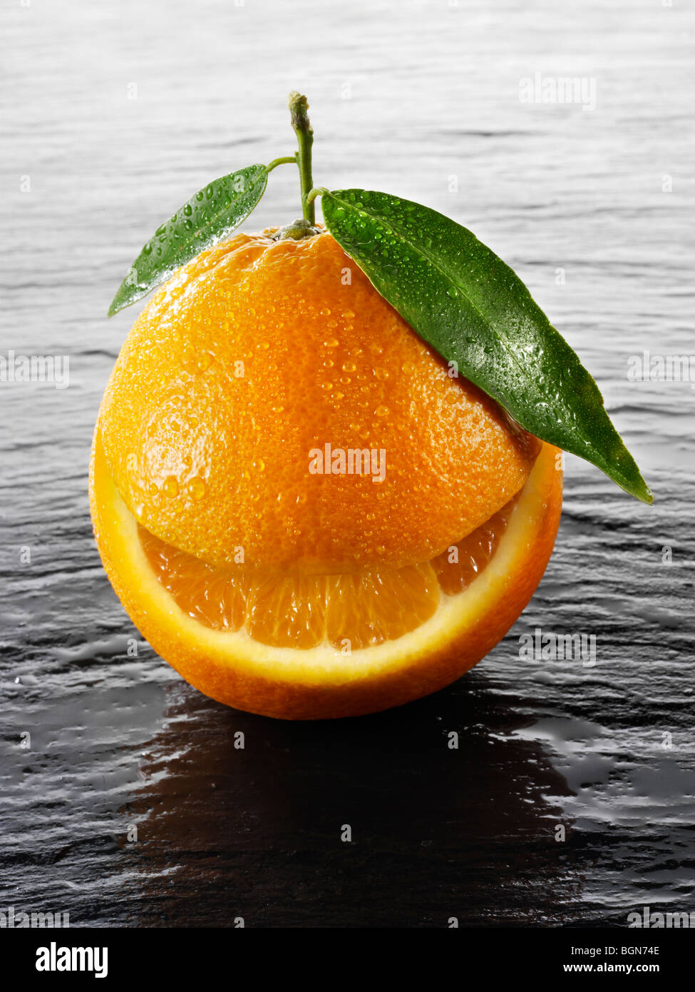 Wole oranges with a smiley face on a black background Stock Photo